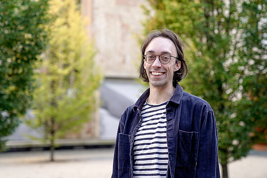 Ein Mann mit Brille lächelt in die Kamera